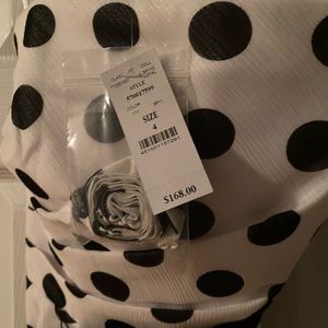 White and black polka dot dress with black sash.